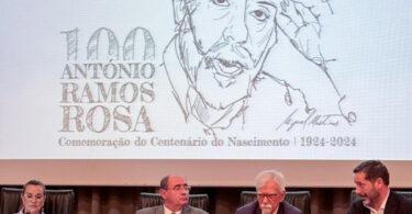 Evento centenário António Ramos Rosa, palestrantes sentados, auditório.